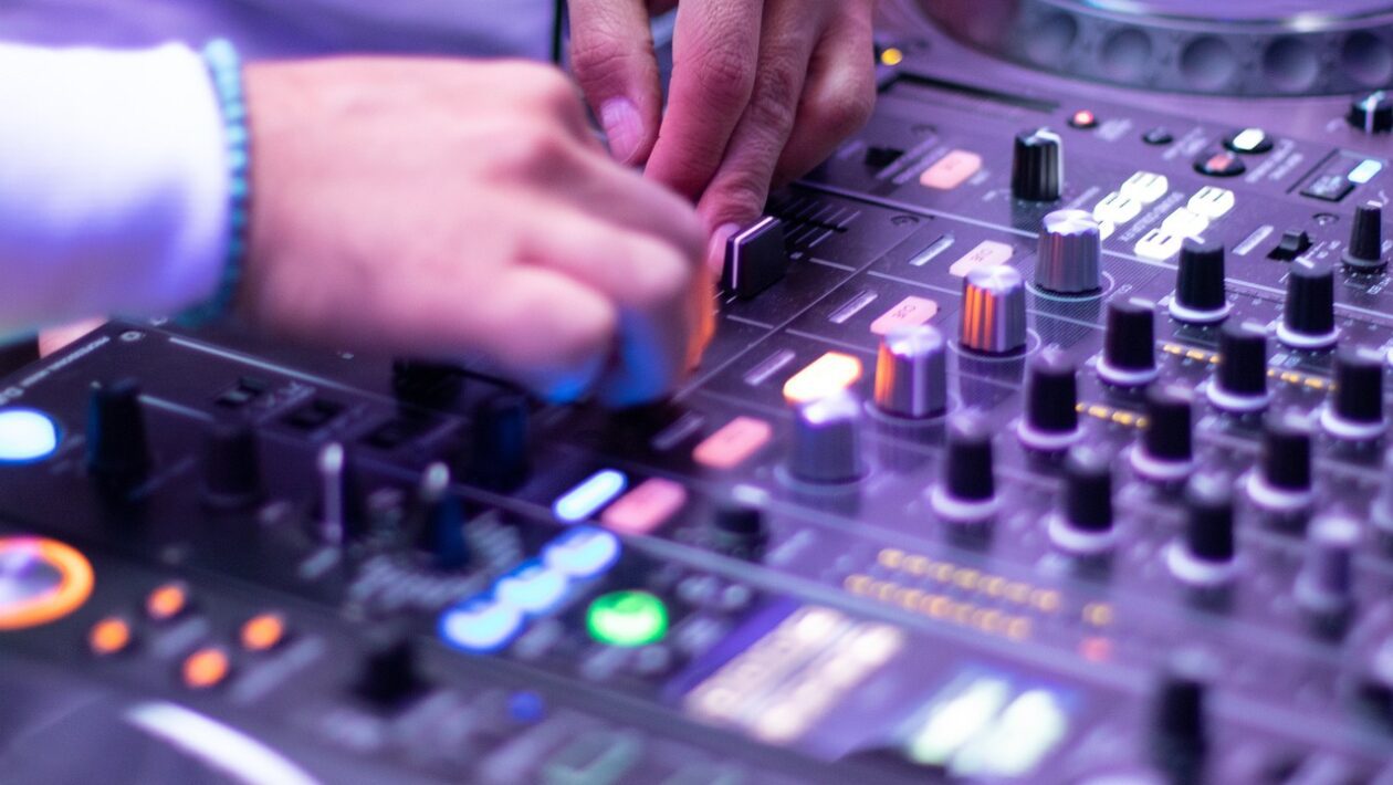 Song von Gigi D’Agostino für rechte Parolen missbraucht. Auf dem Foto sieht man Hände, die auf DJ-Equipment spielen.