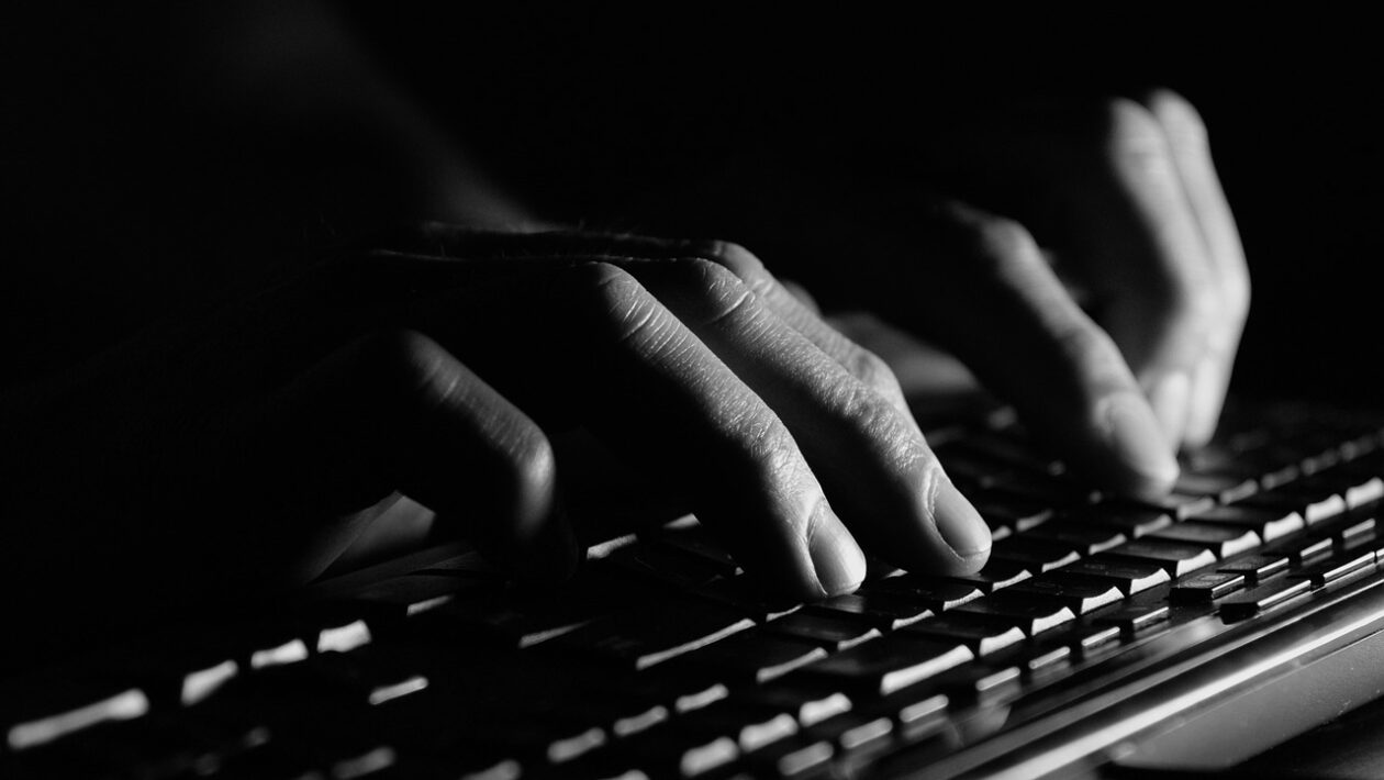Beitragbild: Über uns – Bereich. Das Foto zeigt eine schwarz-weiß Bild einer Hand, die auf eine Tastatur tippt.
