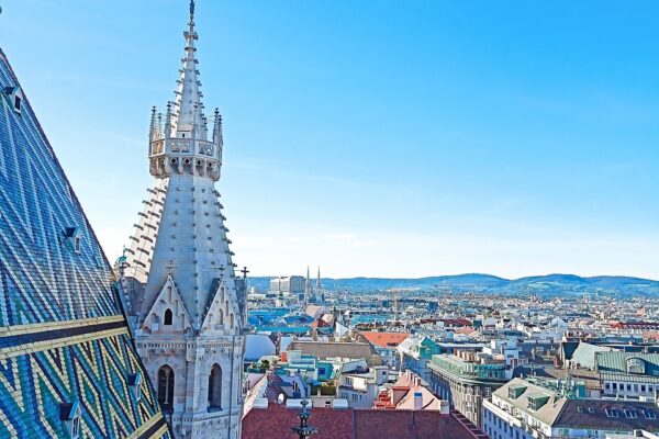 Auf dem Foto sieht man eine Luftaufnahme von der Stadt Wien. Auf der linken Bildseite ist ein Teil Daches vom Stephansdom zu sehen. Und die rechte Bildhälfte fühlt die Wiener Innenstadt aus. Das Bild steht symbolisch für die Wien Hymne.