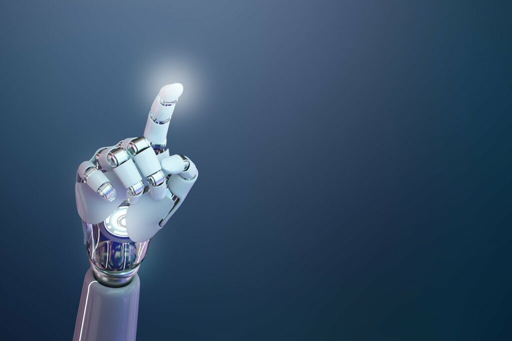 Das Bild zeigt eine futuristische, hochentwickelte Armprothese, die sich deutlich an menschlicher Anatomie orientiert. Die künstliche Hand ist in einem eleganten Weiß gehalten, kombiniert mit silbernen, metallischen Gelenken und Verbindungsstücken, die ein hohes Maß an Beweglichkeit und technischer Raffinesse suggerieren. Die Prothese ist so positioniert, dass der Zeigefinger nach oben zeigt – als würde sie auf etwas hinweisen oder kurz davor sein, etwas zu aktivieren. An der Spitze des Fingers ist ein leichtes Leuchten zu erkennen, was auf eine Interaktion mit digitaler Technologie oder eine symbolische Darstellung von Innovation und Fortschritt hinweisen könnte. Im Hintergrund ist ein glatter Farbverlauf von dunklem Blau zu einem helleren Ton zu sehen, der den Fokus klar auf die Prothese lenkt und eine moderne, beinahe sterile Atmosphäre schafft. Die Bildkomposition vermittelt eine Mischung aus technologischem Optimismus und Präzision. Die Darstellung der Armprothese wirkt nicht nur funktional, sondern fast ästhetisch – sie steht sinnbildlich für den Fortschritt in der Medizintechnik, insbesondere in der Prothetik und Robotik.