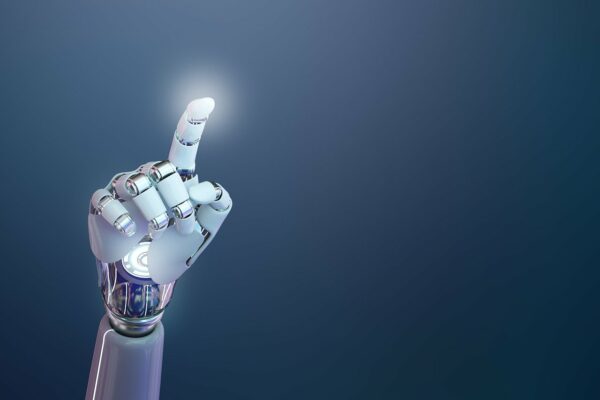 Das Bild zeigt eine futuristische, hochentwickelte Armprothese, die sich deutlich an menschlicher Anatomie orientiert. Die künstliche Hand ist in einem eleganten Weiß gehalten, kombiniert mit silbernen, metallischen Gelenken und Verbindungsstücken, die ein hohes Maß an Beweglichkeit und technischer Raffinesse suggerieren. Die Prothese ist so positioniert, dass der Zeigefinger nach oben zeigt – als würde sie auf etwas hinweisen oder kurz davor sein, etwas zu aktivieren. An der Spitze des Fingers ist ein leichtes Leuchten zu erkennen, was auf eine Interaktion mit digitaler Technologie oder eine symbolische Darstellung von Innovation und Fortschritt hinweisen könnte. Im Hintergrund ist ein glatter Farbverlauf von dunklem Blau zu einem helleren Ton zu sehen, der den Fokus klar auf die Prothese lenkt und eine moderne, beinahe sterile Atmosphäre schafft. Die Bildkomposition vermittelt eine Mischung aus technologischem Optimismus und Präzision. Die Darstellung der Armprothese wirkt nicht nur funktional, sondern fast ästhetisch – sie steht sinnbildlich für den Fortschritt in der Medizintechnik, insbesondere in der Prothetik und Robotik.